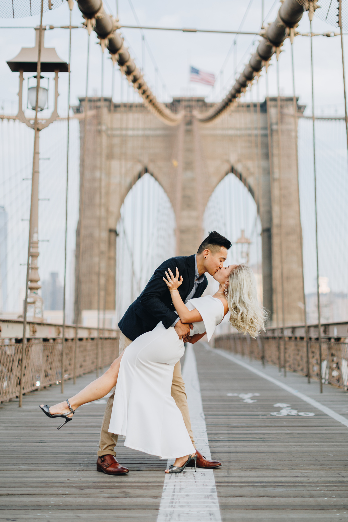 Iconic Brooklyn Bridge engagement photo with bride in white dress