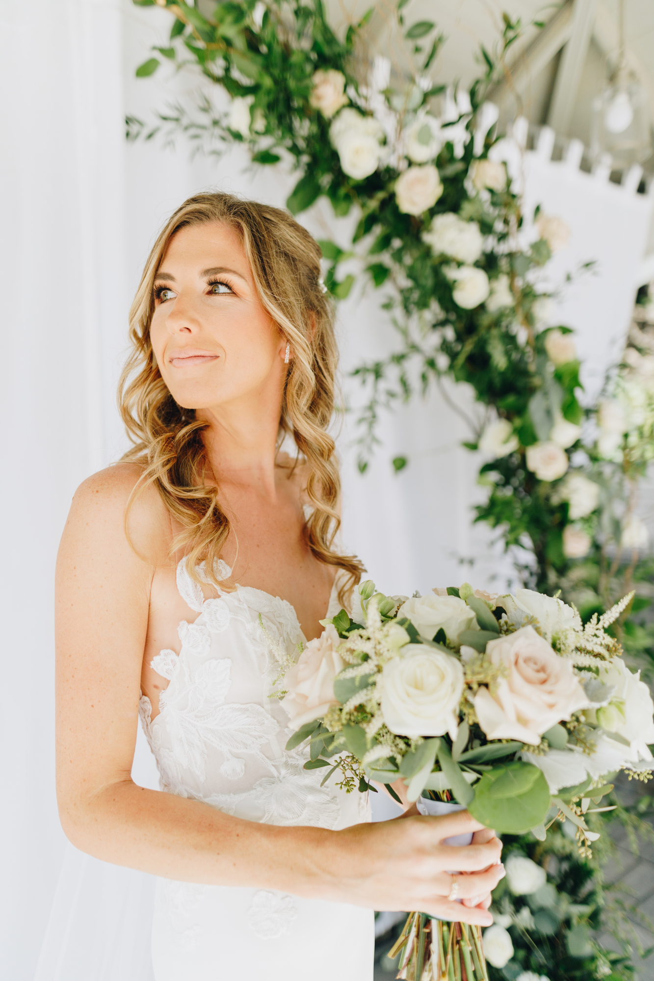 Bridal portrait before backyard wedding with floral arch