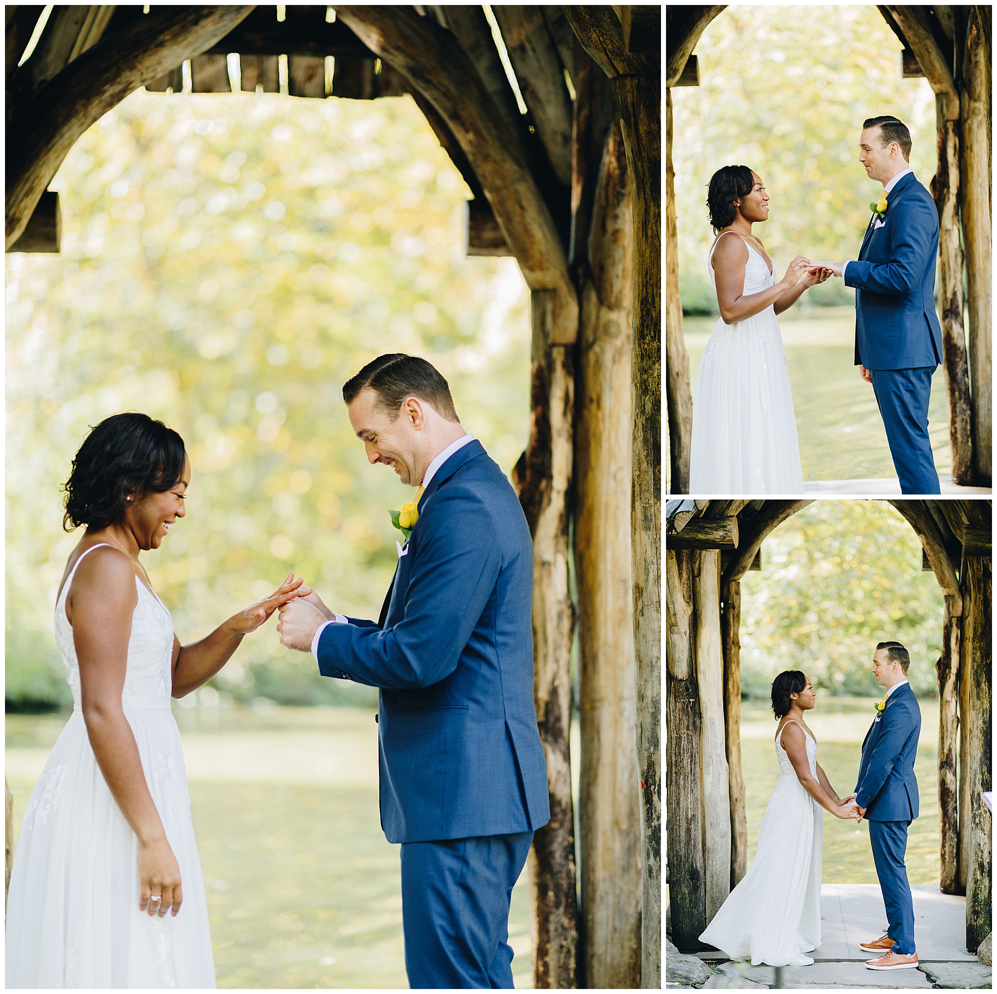 A bride and groom exchange rings and hold hands under a rustic wooden arch outdoors during their Wagner Cove elopement, both smiling in wedding attire, surrounded by lush greenery.