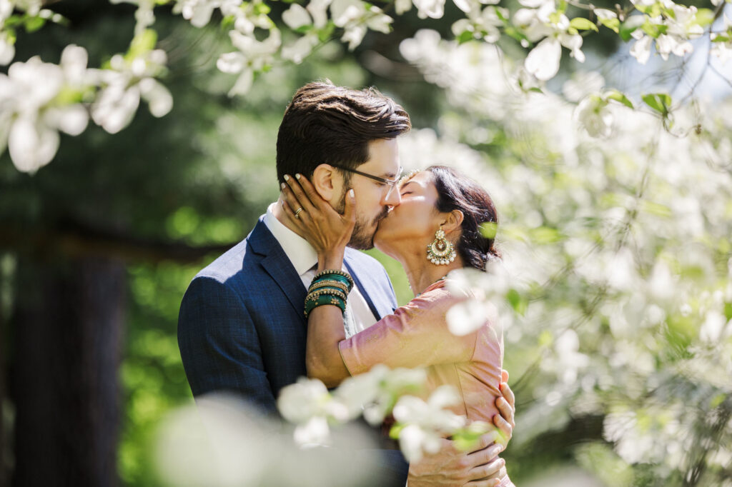 Couple kissing among spring blossoms at their Vanderbilt Mansion elopement in Hyde Park