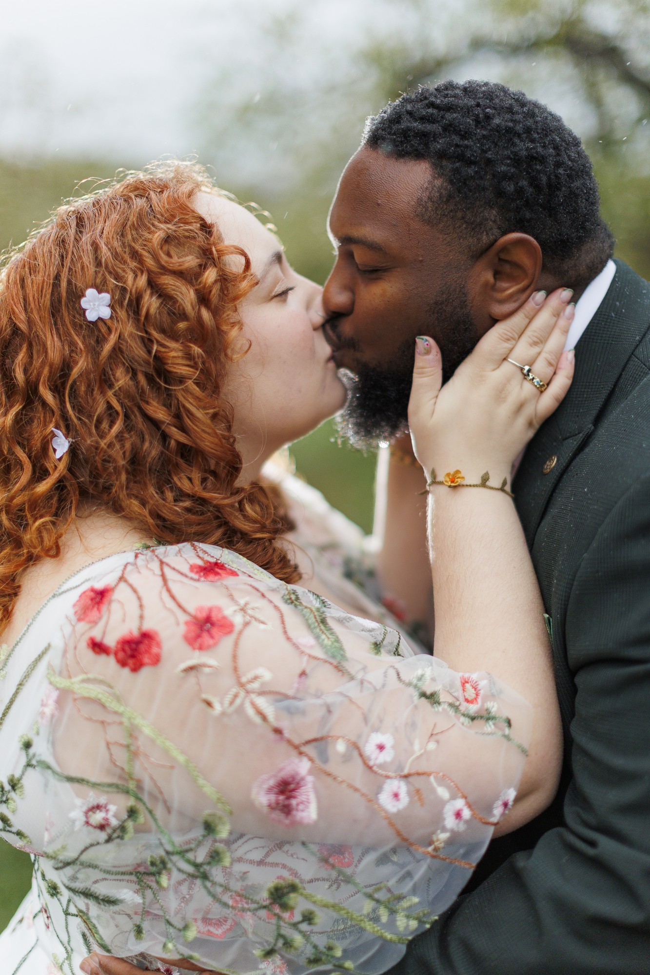 Couple kissing outdoors during Hudson Valley wedding photography session with bride in floral dress and groom in suit