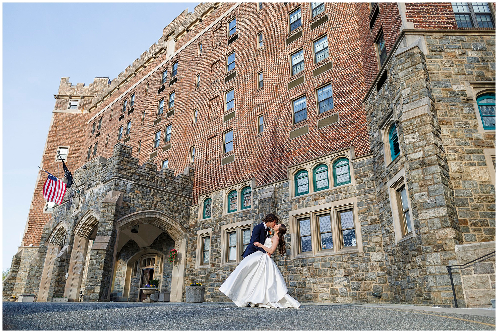 Bride and groom kissing in front of a historic stone castle building, captured by Hudson Valley wedding photographers specializing in wedding photography and videography