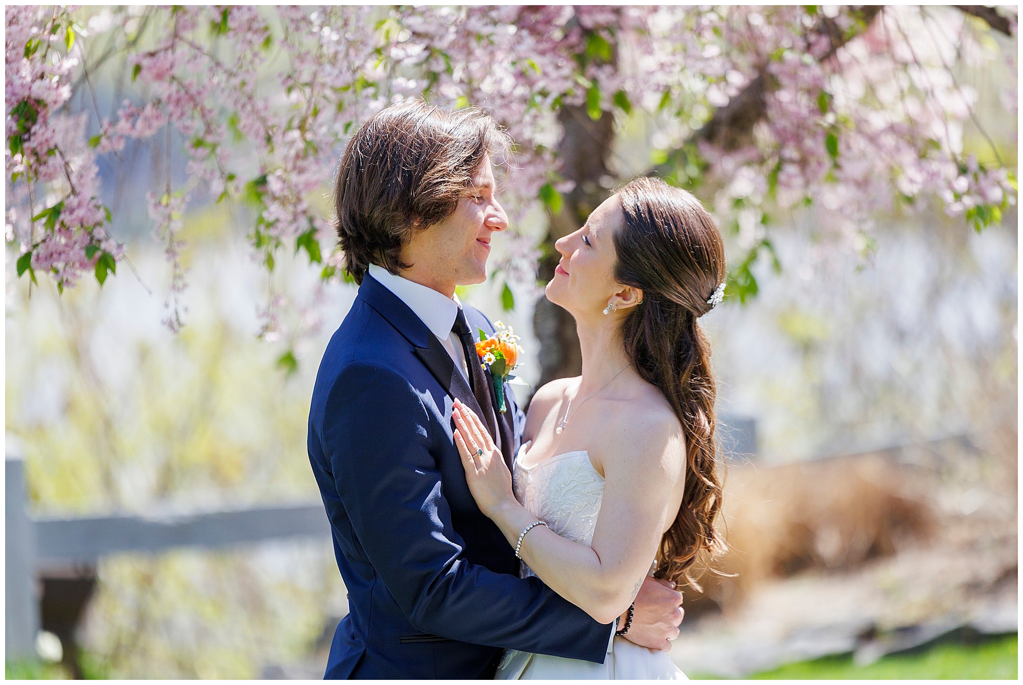 Newlyweds gazing at each other under cherry blossom trees at The Thayer Hotel, photographed by a wedding photography team