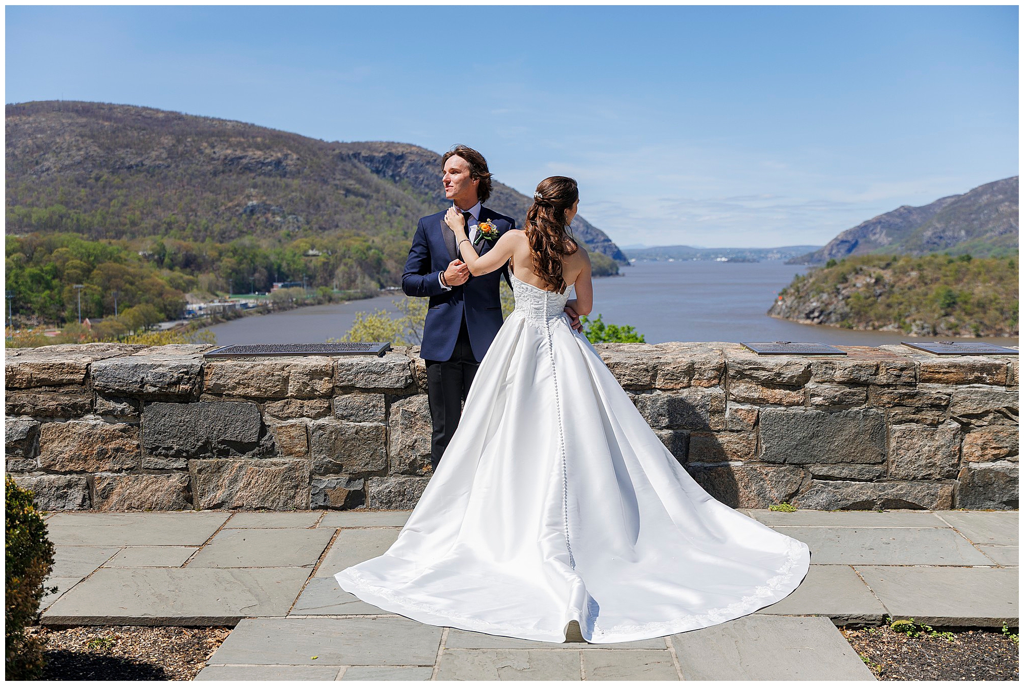 Bride's ballgown billowing in the breeze at a stone overlook at The Thayer Hotel at West Point