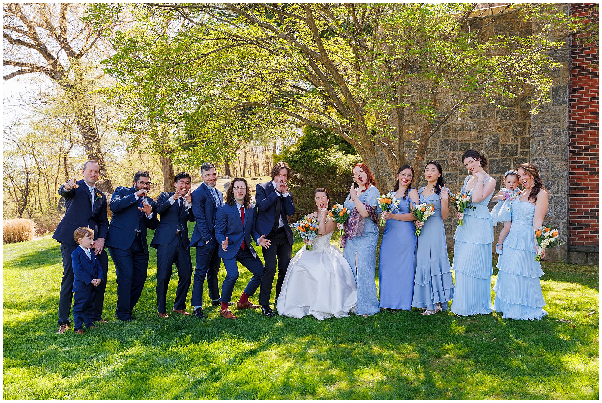 Groomsmen in navy suits posed for a group portrait on the lawn at The Thayer Hotel, Hudson Valley wedding