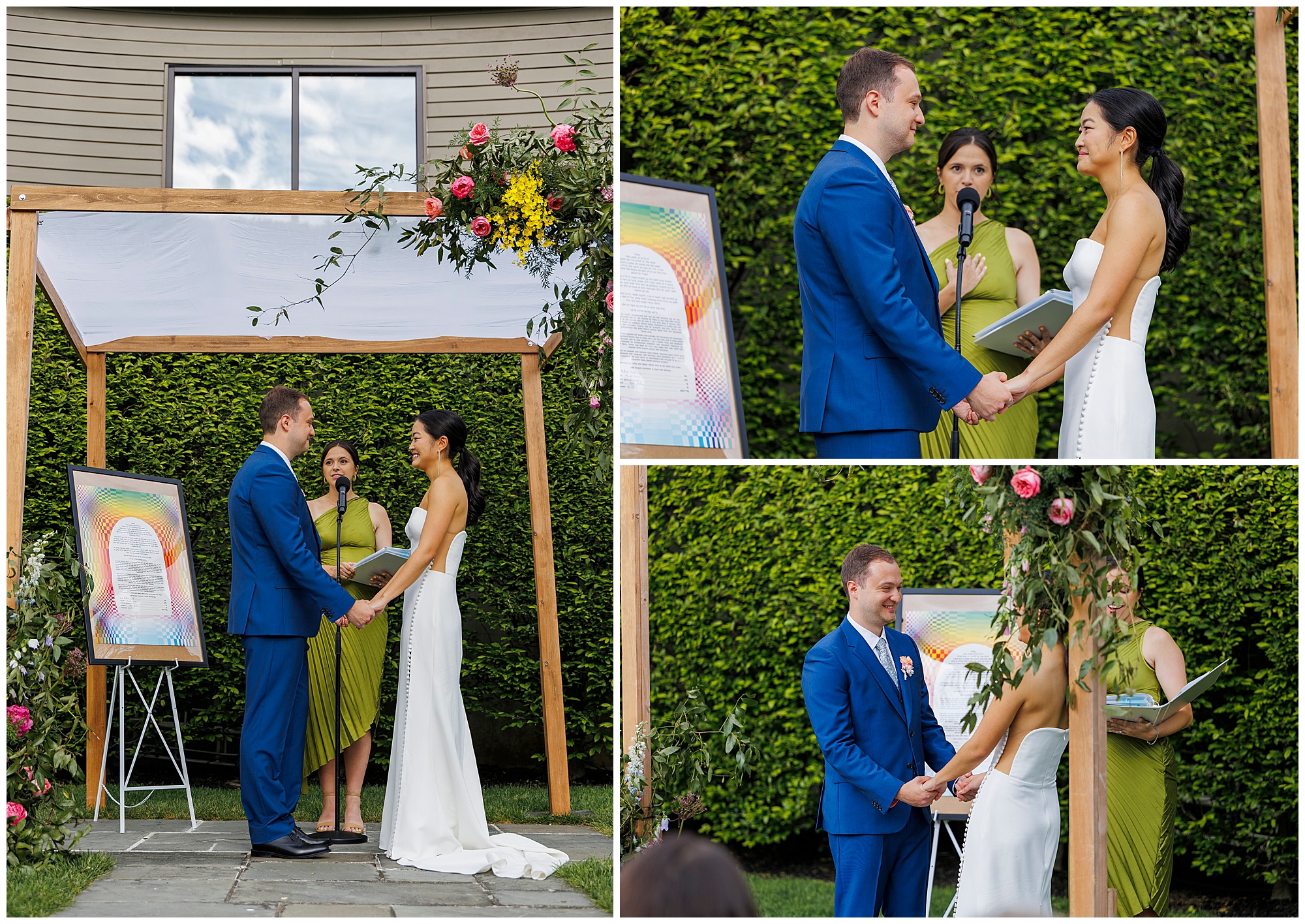 A bride and groom stand under an outdoor floral arch at their roundhouse wedding, holding hands as an officiant speaks. A colorful framed art piece is displayed beside them in the lush, green garden setting.