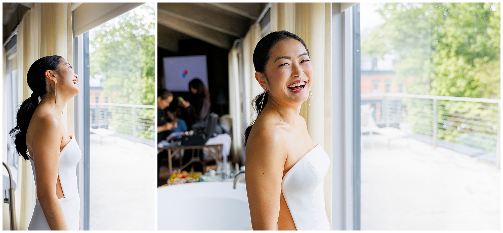 A woman in a strapless white dress stands by large windows at her roundhouse wedding, smiling and laughing. Bright natural light fills the modern room, with greenery and a balcony visible outside.