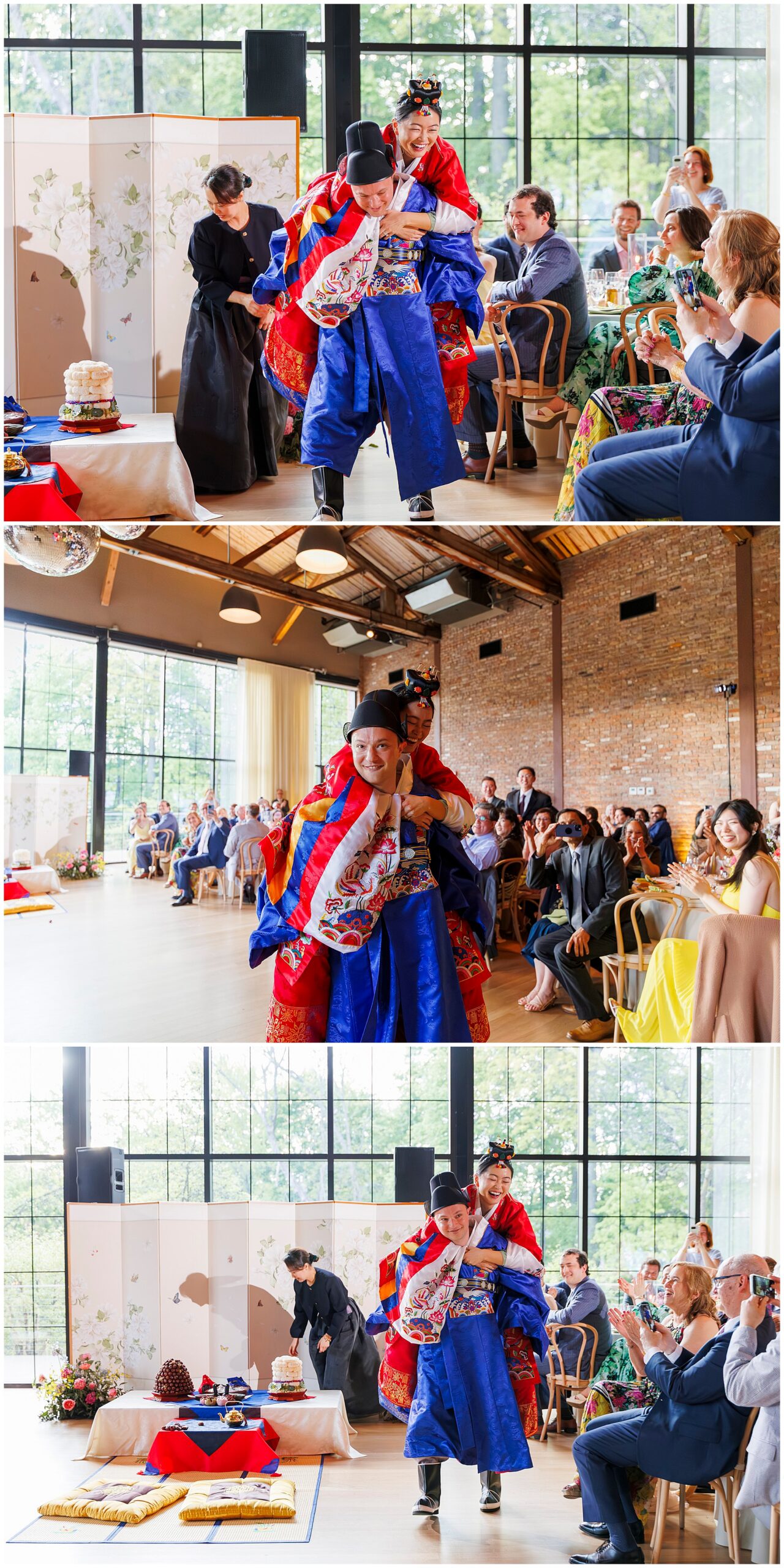 A bride in a traditional Korean hanbok rides on the groom’s back as smiling guests look on and take photos during a colorful roundhouse wedding ceremony indoors.
