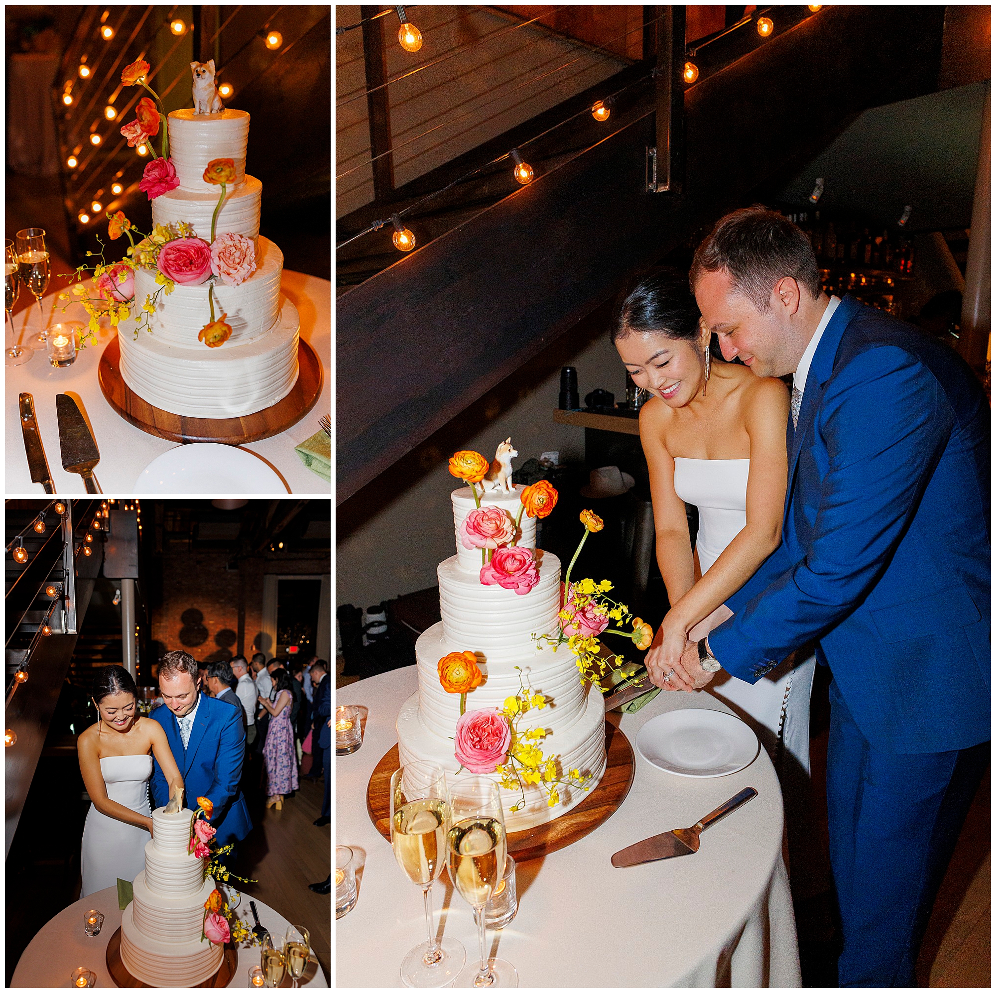 At a roundhouse wedding, a bride and groom, smiling and dressed formally, cut a white tiered cake adorned with colorful flowers and a fox topper. The warmly lit scene features string lights and champagne glasses close by.