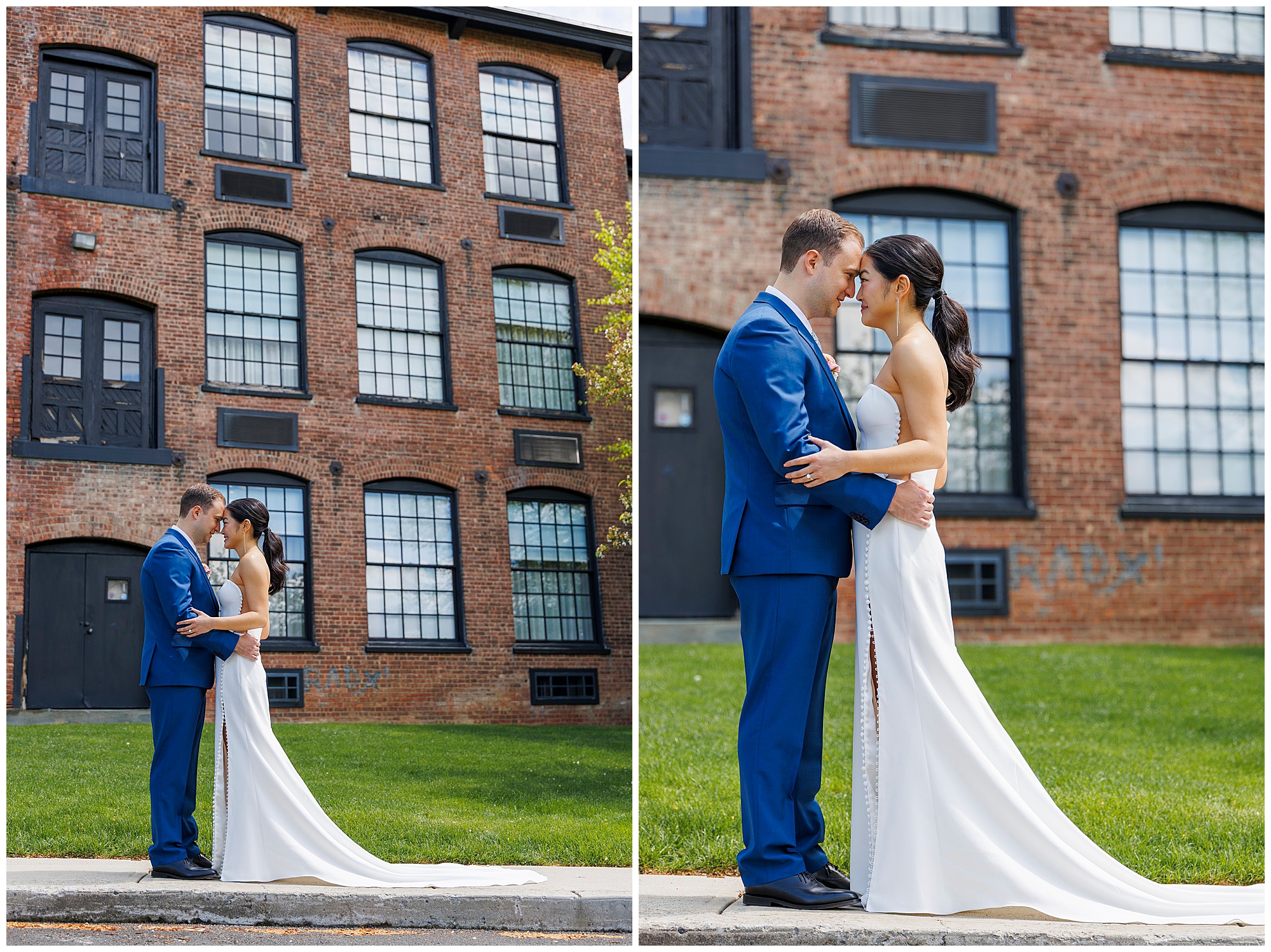 A bride in a white gown and a groom in a blue suit stand close together, embracing and touching foreheads, outside the roundhouse wedding venue’s brick building with large black-framed windows.
