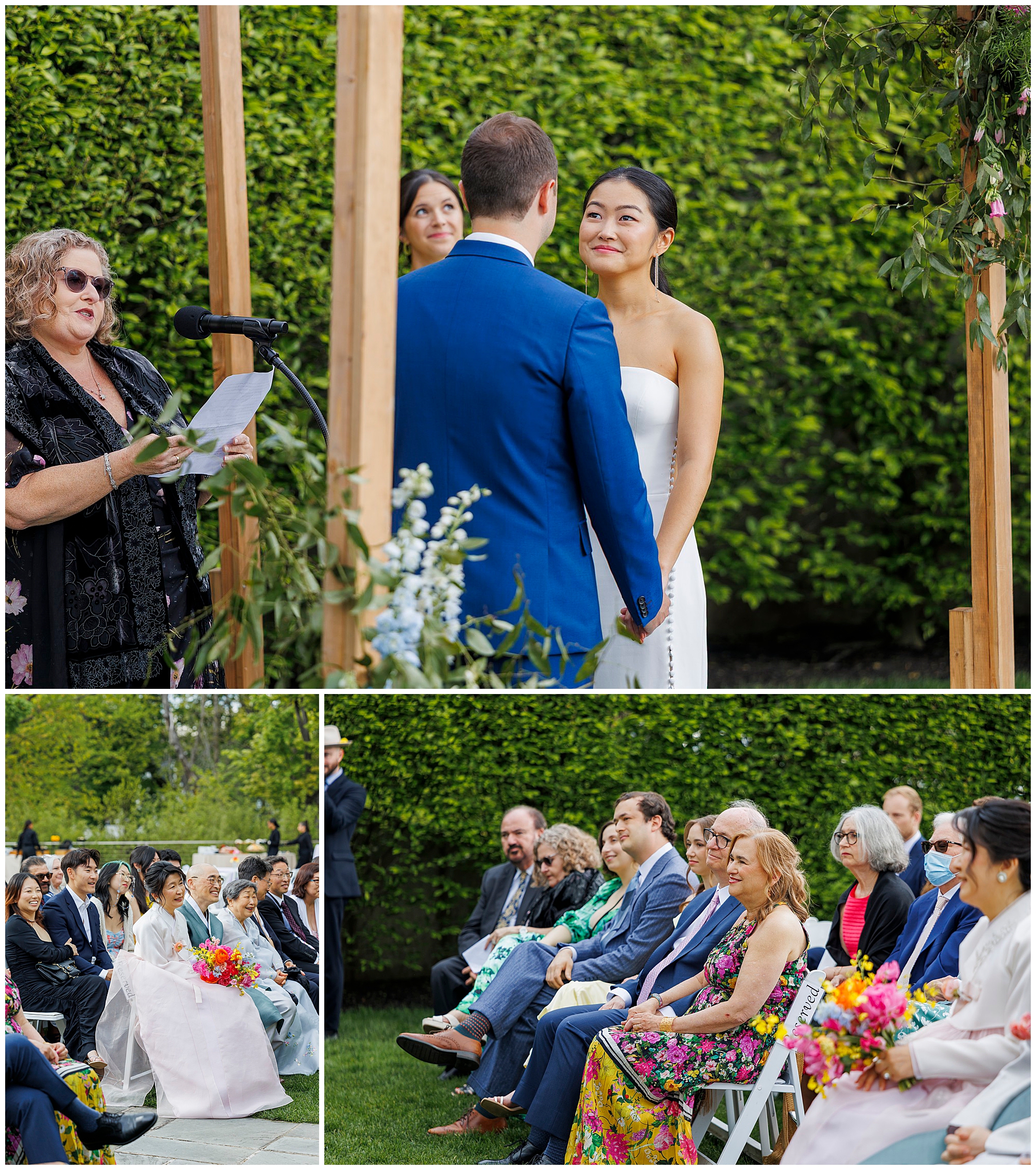 A couple stands under a wooden arch during their roundhouse wedding ceremony, with a woman speaking at a microphone. Guests seated on chairs watch the event, some holding colorful bouquets.
