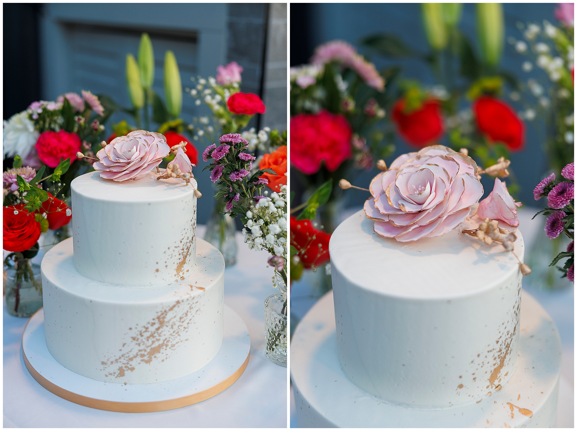 A two-tier white cake with a large pink sugar flower on top, surrounded by vibrant red, purple, and white flowers in vases—perfect for an intimate Harvest on Hudson micro wedding.