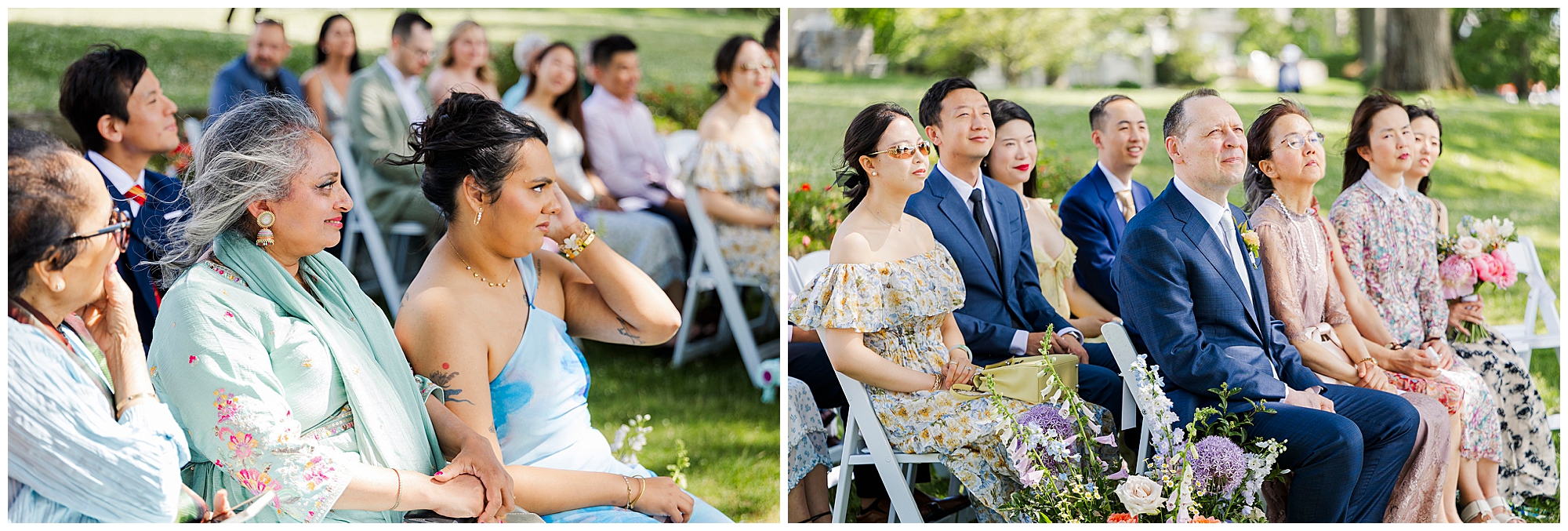 Guests sit outdoors on white chairs, attentively watching an event. They are dressed in formal and semi-formal attire, surrounded by green grass and colorful flower arrangements. The atmosphere appears joyful and serene.