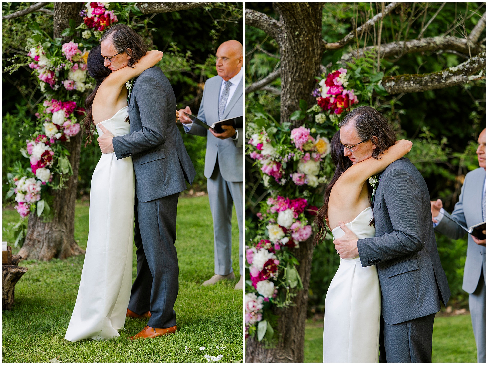 A bride in a white dress hugs an older man in a gray suit outdoors during an Airbnb micro wedding ceremony. Colorful floral arrangements decorate the background as the officiant stands nearby holding a book.