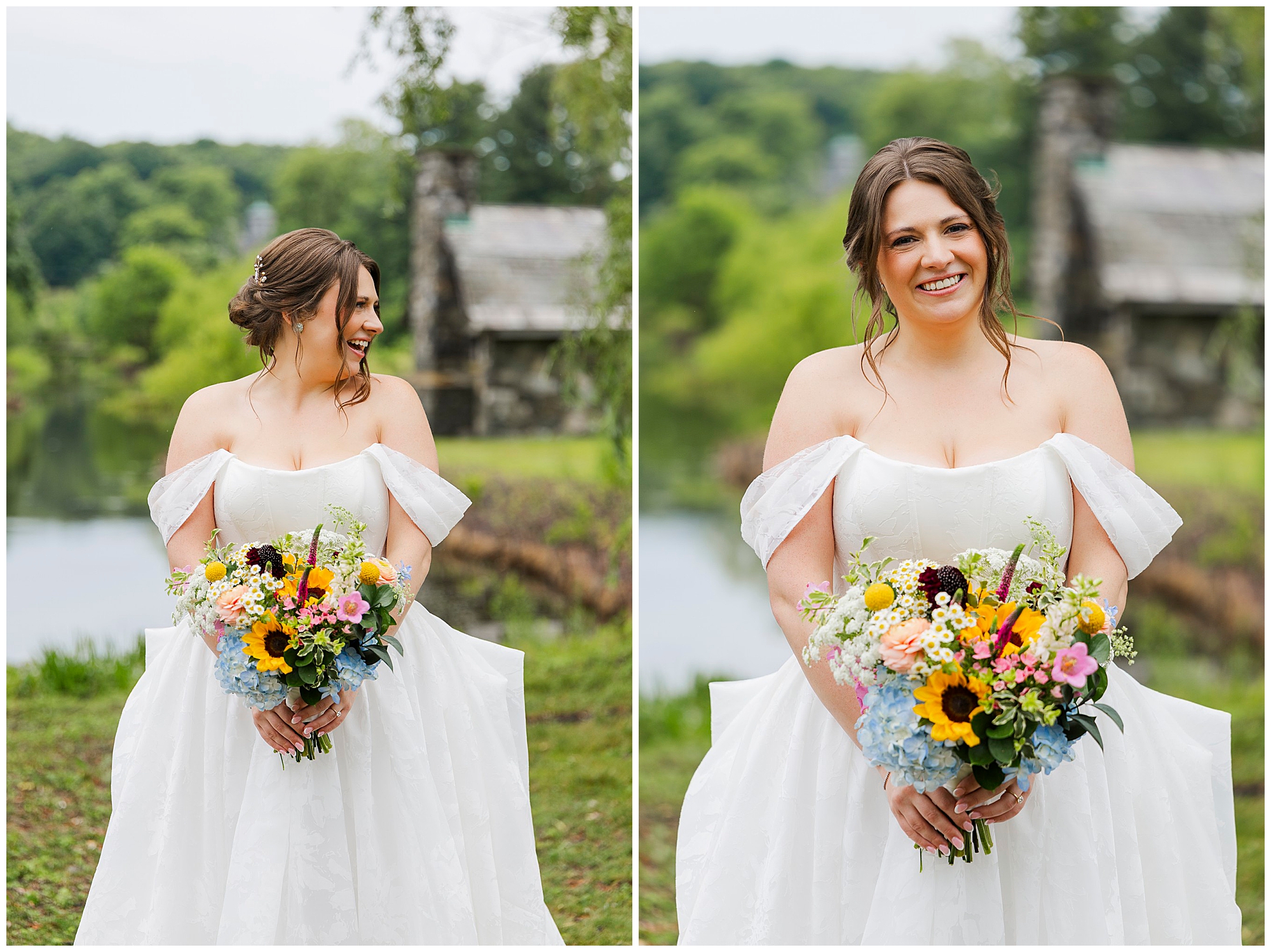 A bride in an off-shoulder white gown holds a colorful bouquet and smiles outdoors at her summer garrison wedding, with green trees, a pond, and a rustic stone building in the background.