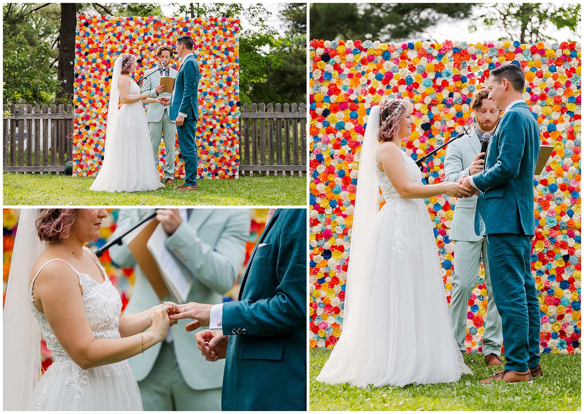 A bride and groom exchange vows and rings outdoors during a wedding at the yard, in front of a colorful floral backdrop, with an officiant beside them. The couple, dressed in wedding attire, appears joyful.