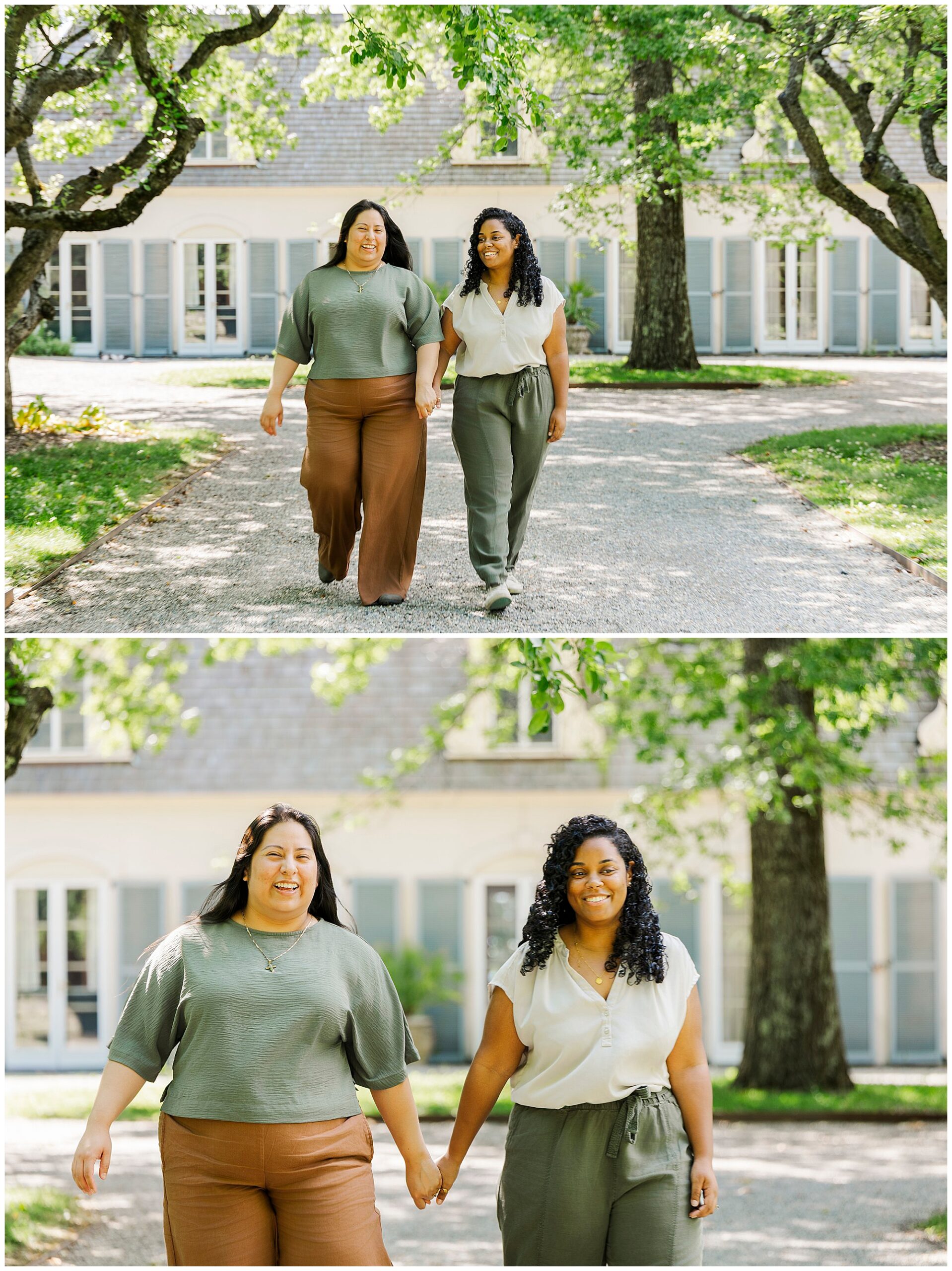 Two women walk hand in hand on a tree-lined path in front of a large house with blue shutters, smiling and enjoying each other's company during their LGBTQ engagement photos at Stonecrop Gardens on a sunny day.