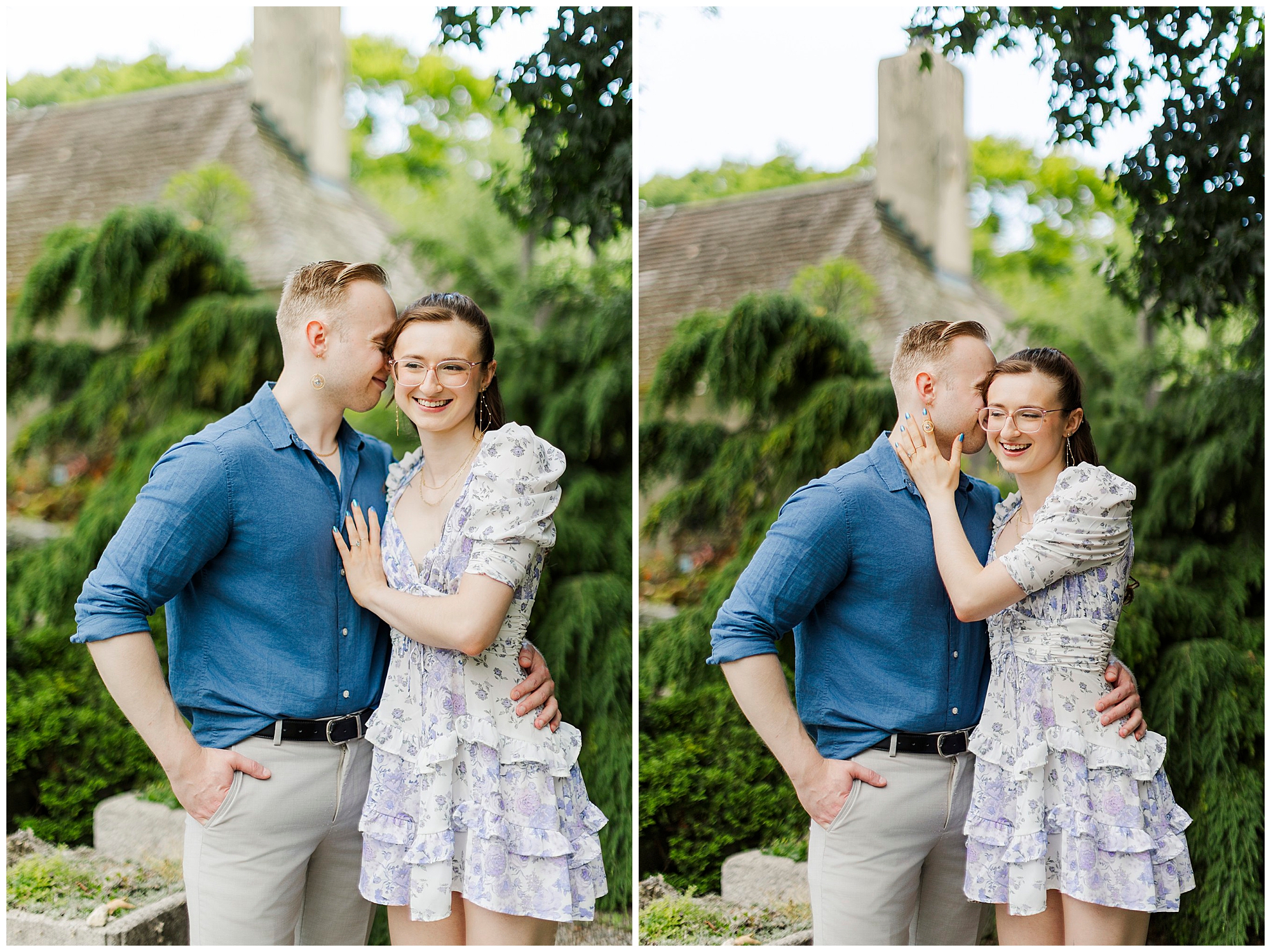 A couple stands close together outdoors, smiling and embracing during their engagement pictures at Stonecrop Gardens. The woman wears a floral dress and glasses; the man wears a blue shirt and light pants. Greenery forms a lovely backdrop to their happiness.