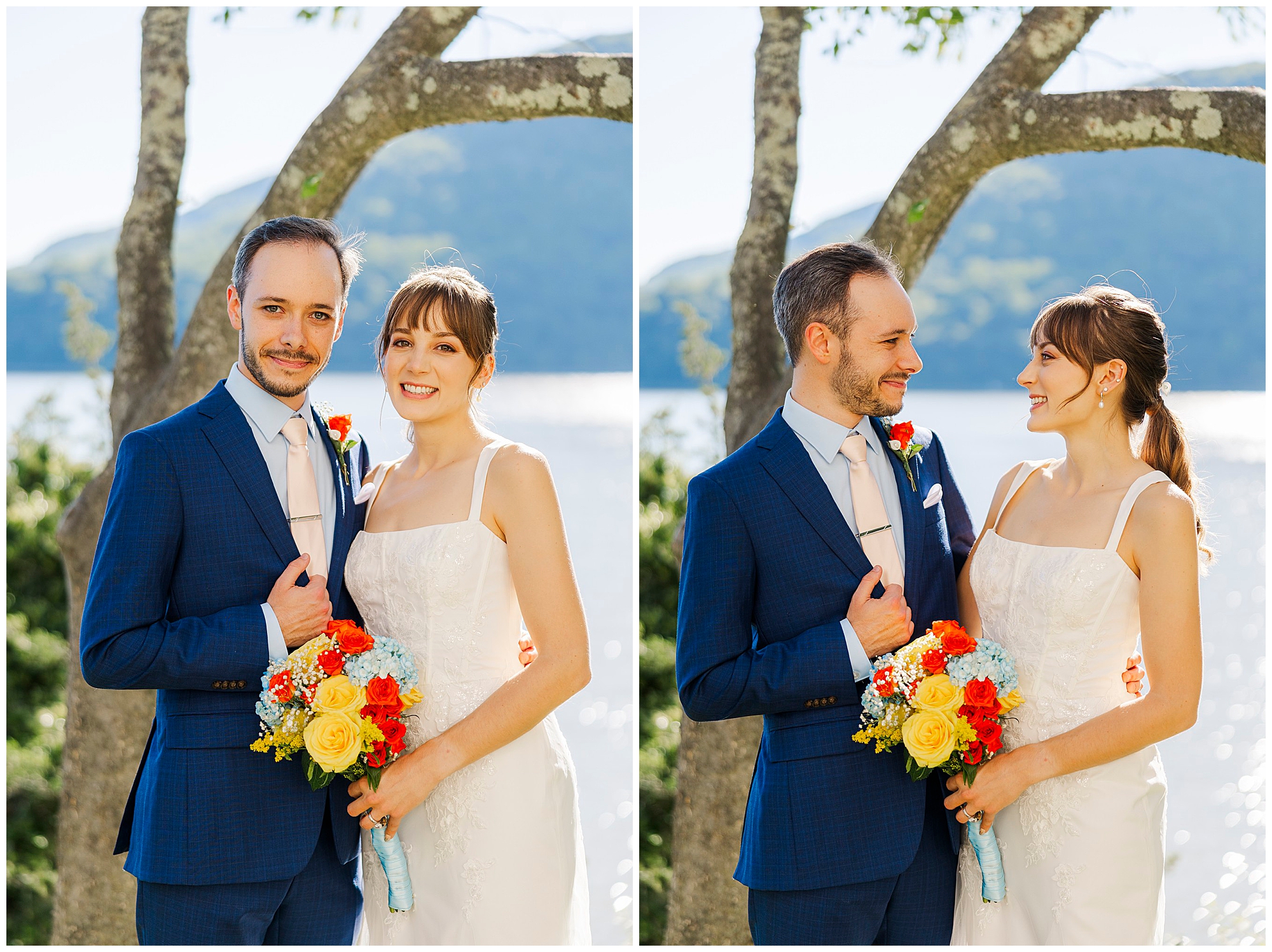 Smiling bride and groom pose by the water, the bride holding a colorful bouquet, with trees and hills in the sunny background.