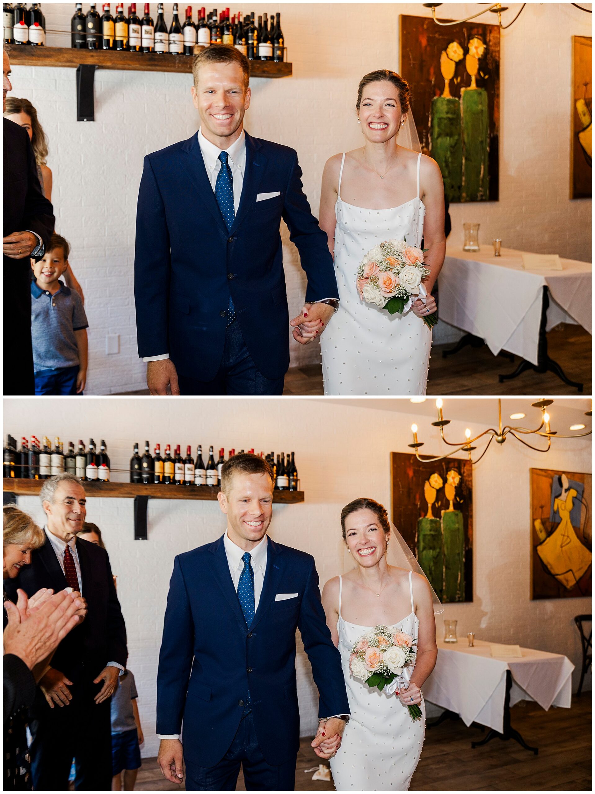A smiling couple, dressed in wedding attire, walks hand-in-hand down an aisle in the warmly lit Cafe Alaia during their intimate micro-wedding, while guests applaud and watch.