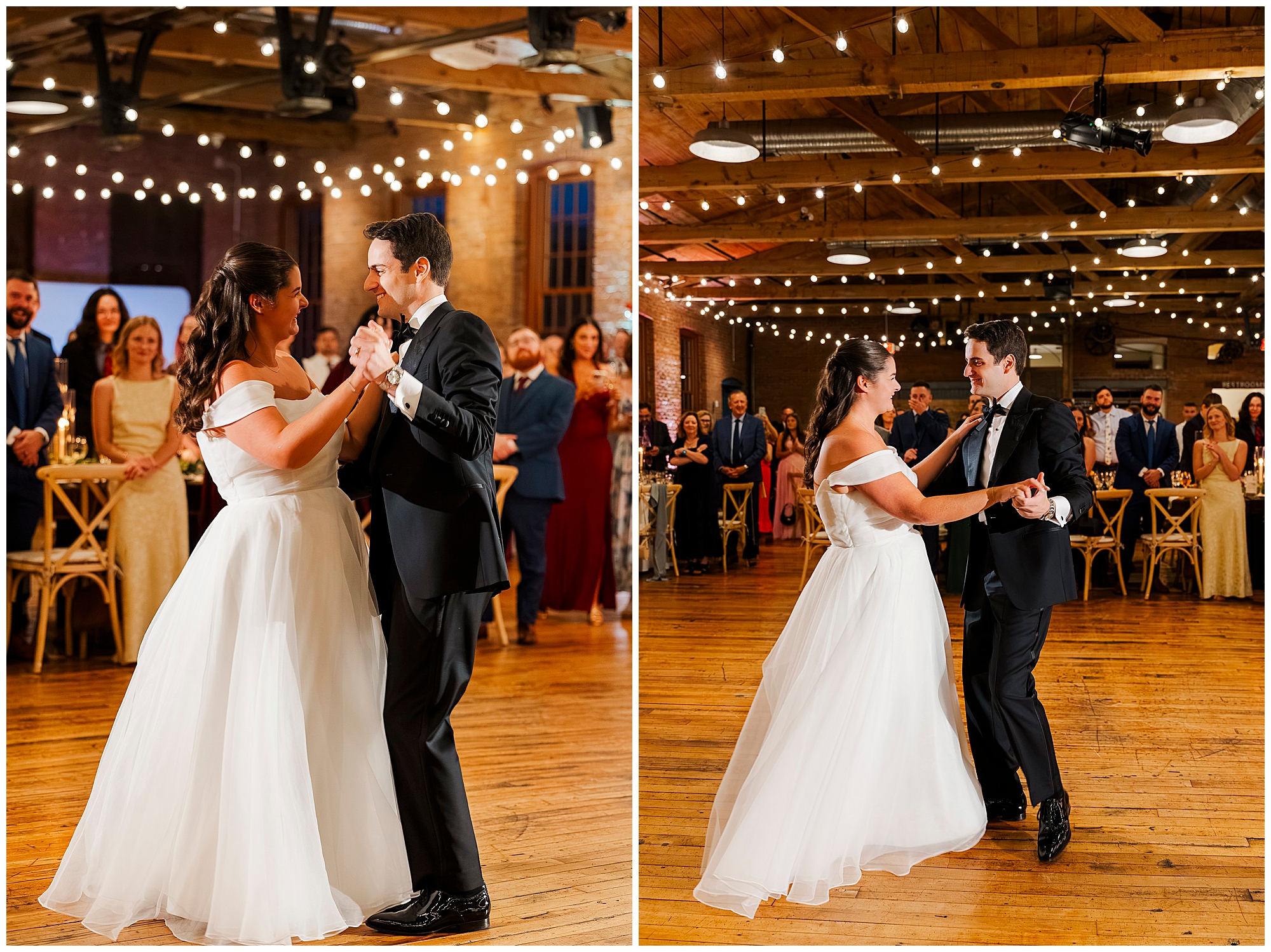 A bride and groom share their first dance at a wedding reception, smiling and holding hands, surrounded by guests and string lights in a rustic venue.
