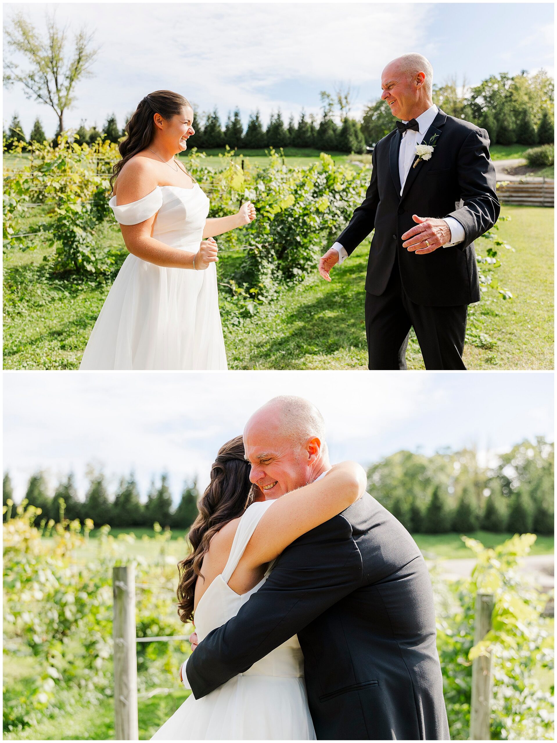 A bride in a white dress smiles and embraces a man in a suit outdoors on a sunny day, surrounded by greenery and trees.